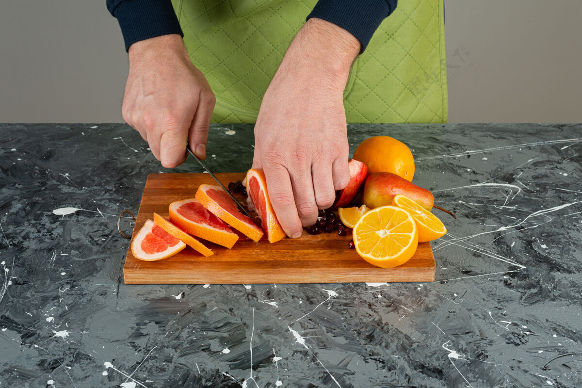 水果男性手戴手套在大理石桌上切多汁的葡萄柚手套有机刀