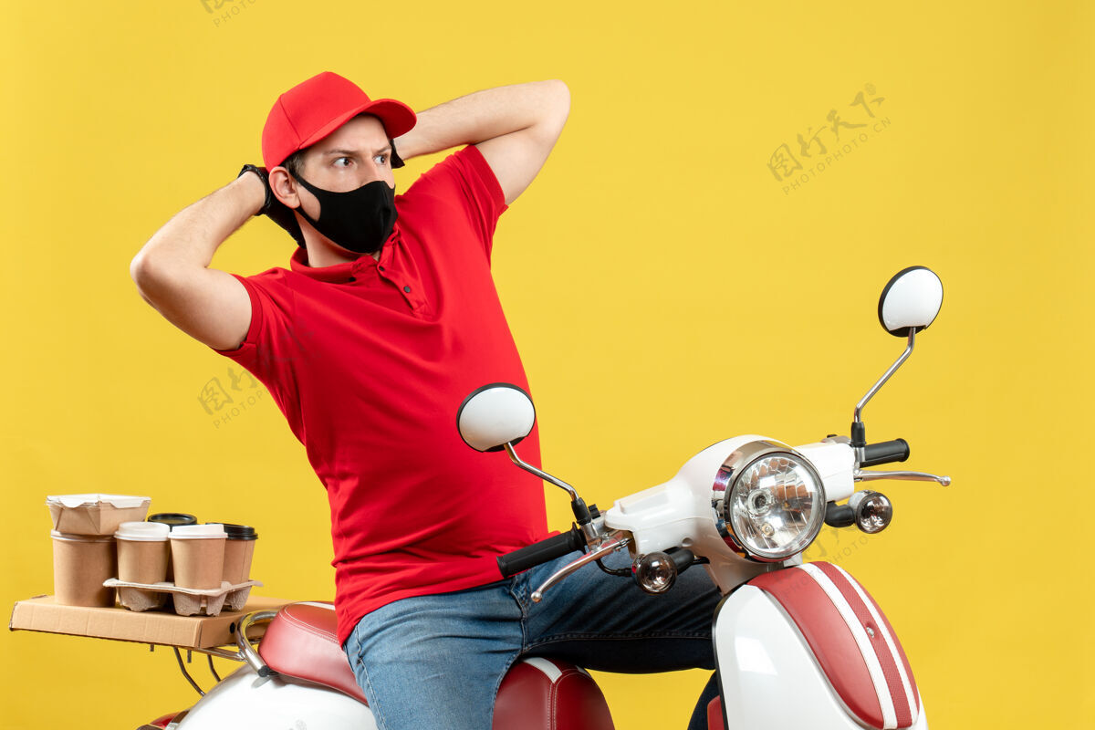 混乱俯视图：快递员身穿红色上衣 戴着帽子手套 戴着医用口罩 坐在滑板车上发订单 感觉很困惑感情人坐