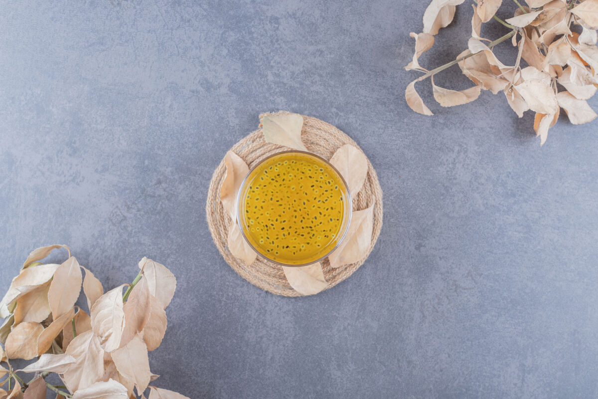 圆形在灰色背景的木板上放上新鲜的橘子汁健康玻璃杯水果