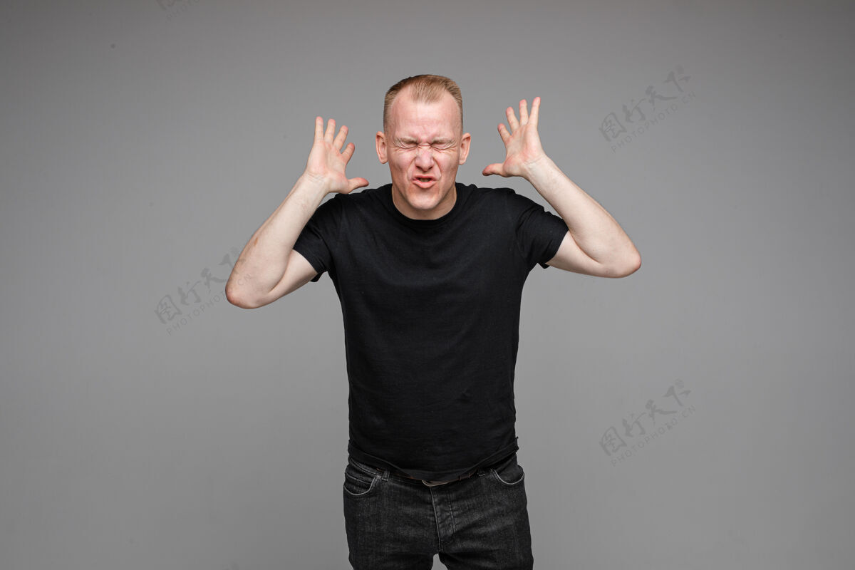 男性一张白种人的照片 他把双手放在头上 愤怒地孤立在灰色的墙上休闲单身愤怒