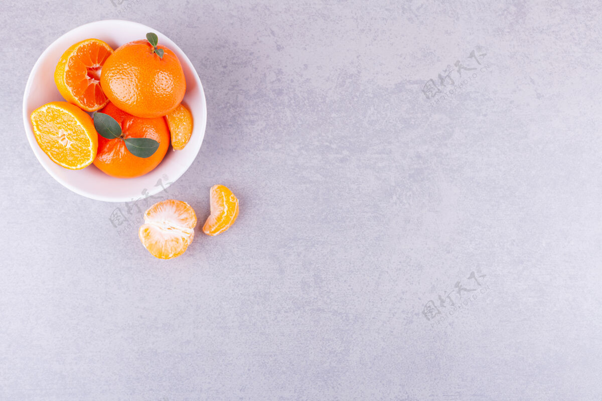 克莱门汀整个和切片的橘子叶放在石桌上美味食物美味