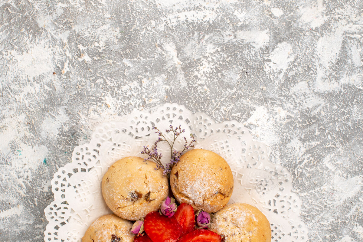 冬天白色表面上有新鲜草莓的美味沙曲奇俯视图食物雪草莓