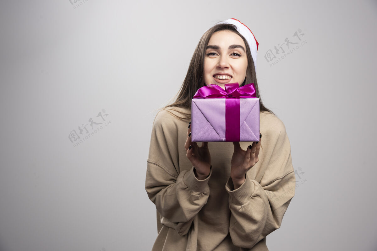 表情微笑的女人拿着一盒圣诞礼物女性人成人