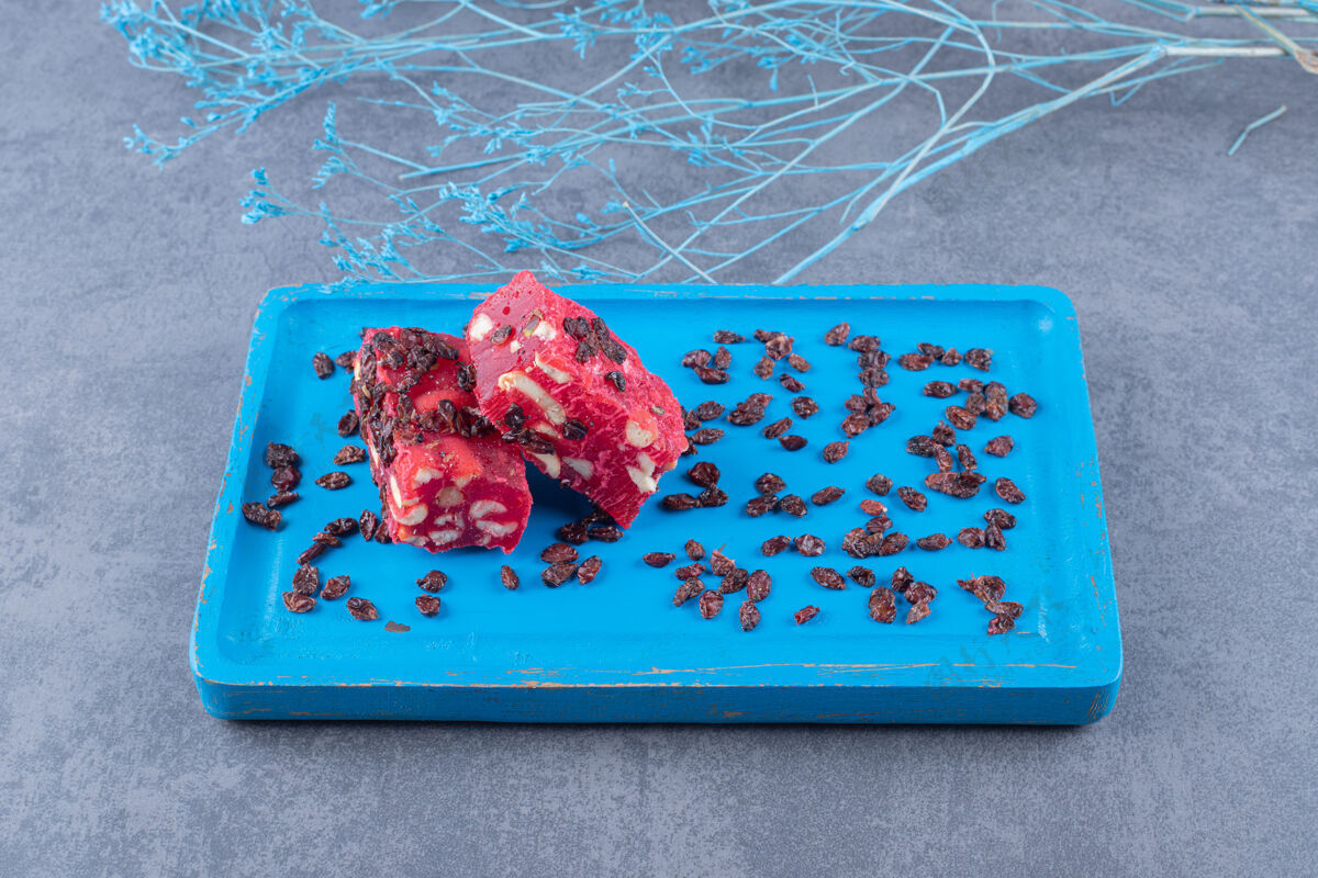 犹太土耳其美食rahatlokum的俯视图 蓝色木板上有开心果和干葡萄干糖甜点晚餐