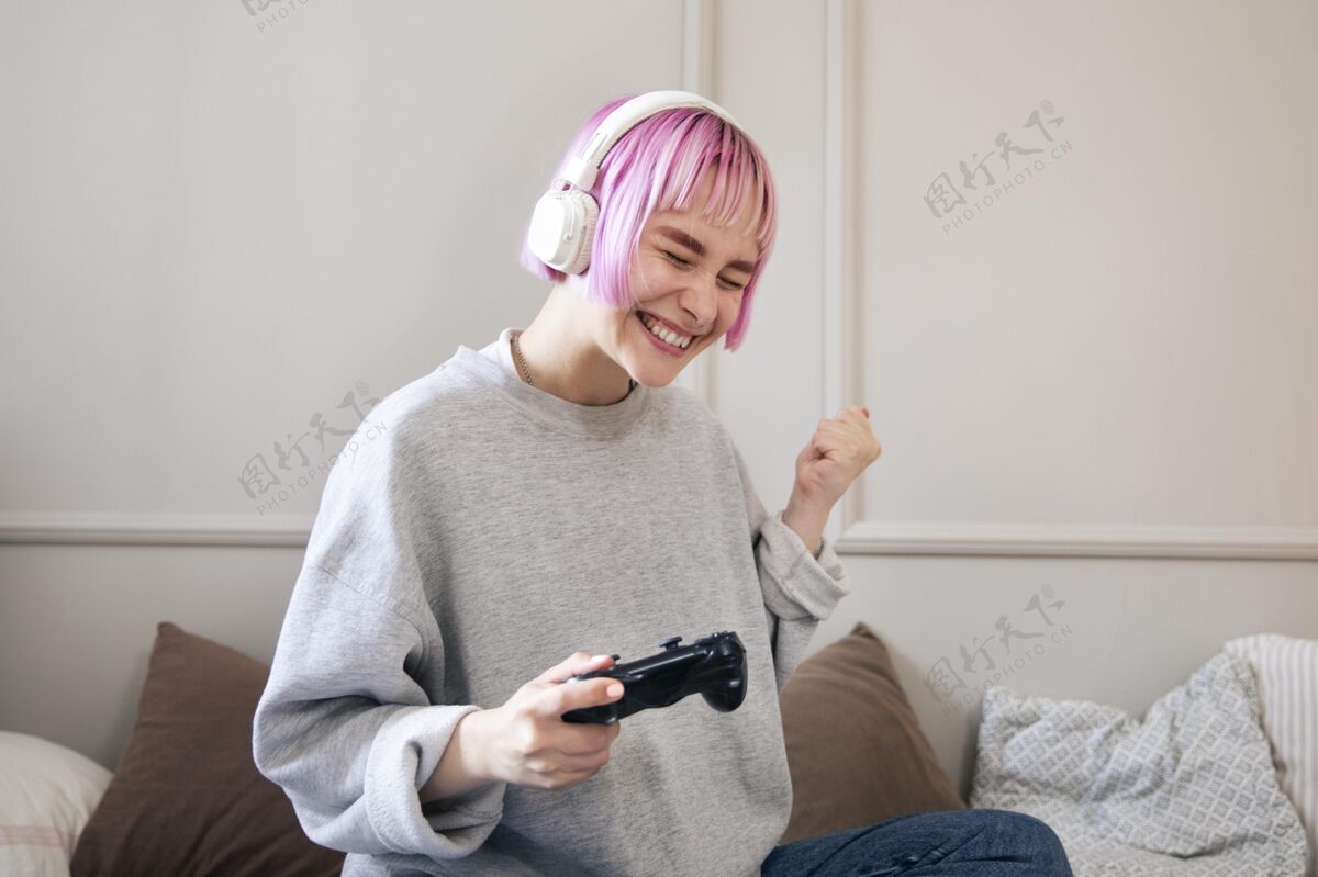虚拟粉红色头发的年轻女子在玩电子游戏乐趣在线数字