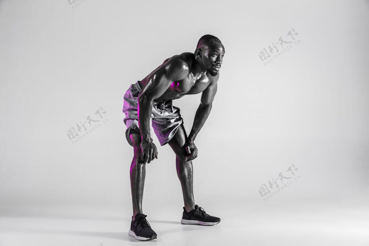 休息无所畏惧在灰色背景下拍摄的年轻非裔美国健美运动员训练的摄影棚镜头穿着运动服站立的肌肉发达的单身男模运动 健美 健康生活方式的概念赛车健身健美