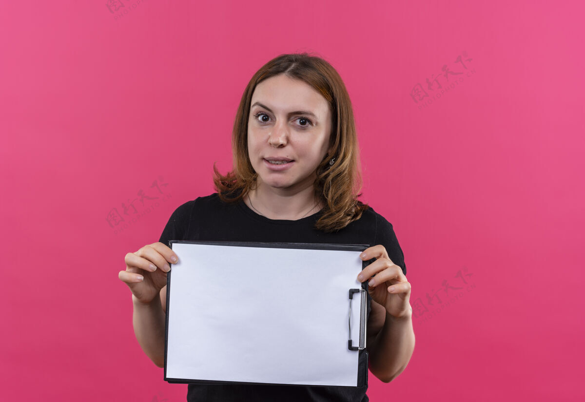 女士高兴的年轻随意的女人拿着剪贴板上孤立的粉红色空间与复印空间请空格拿着