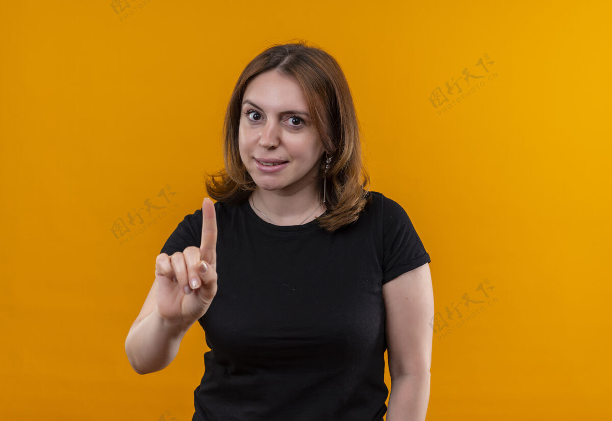 女人令人印象深刻的年轻休闲女子举起手指在孤立的橙色空间与复制空间手指提高印象