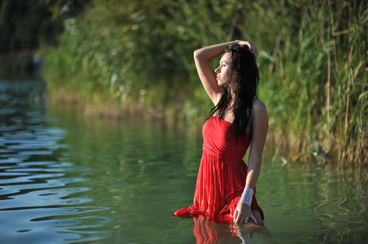 女人夏天的年轻女子红色长裙在户外摆姿势性感人时髦