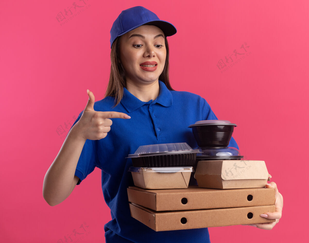 盒子一个穿着制服的焦急漂亮的女送货员拿着并指着食物包和比萨饼盒上的容器送货女人包装