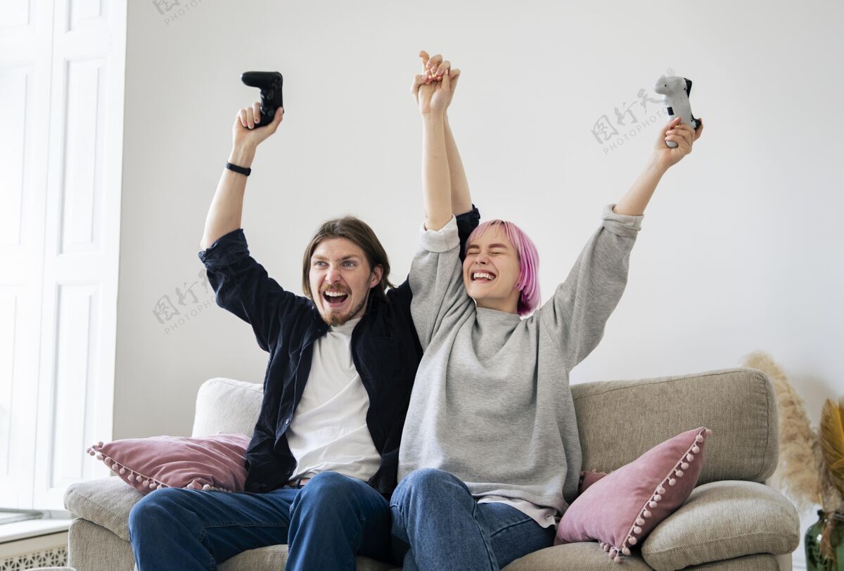玩家年轻夫妇在家玩电子游戏科技男人娱乐