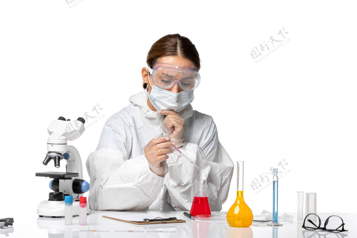 白人前视图穿着防护服 戴着口罩的女医生正在处理白色背景的冠状病毒大流行病毒病毒药品医生