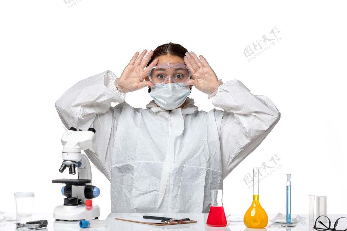 外套前视图：穿着防护服 戴着口罩的女医生坐在白色背景病毒的溶液里-健康大流行医疗女医生药