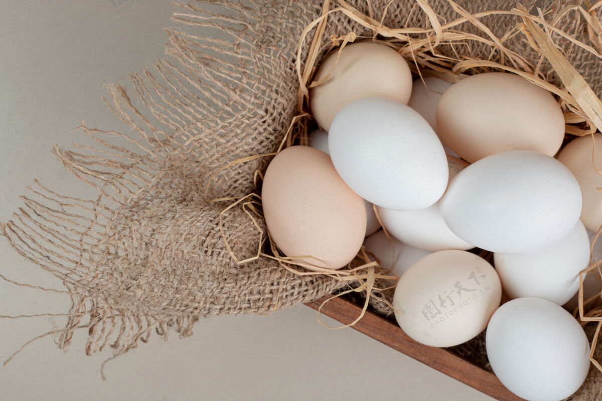 生的新鲜的鸡蛋和干草放在木篮里食物未经料理的鸡肉