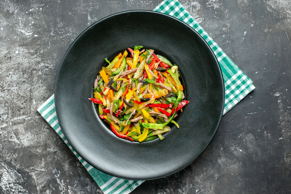 食物黑色表面上美味蔬菜沙拉的俯视图健康蔬菜盘子
