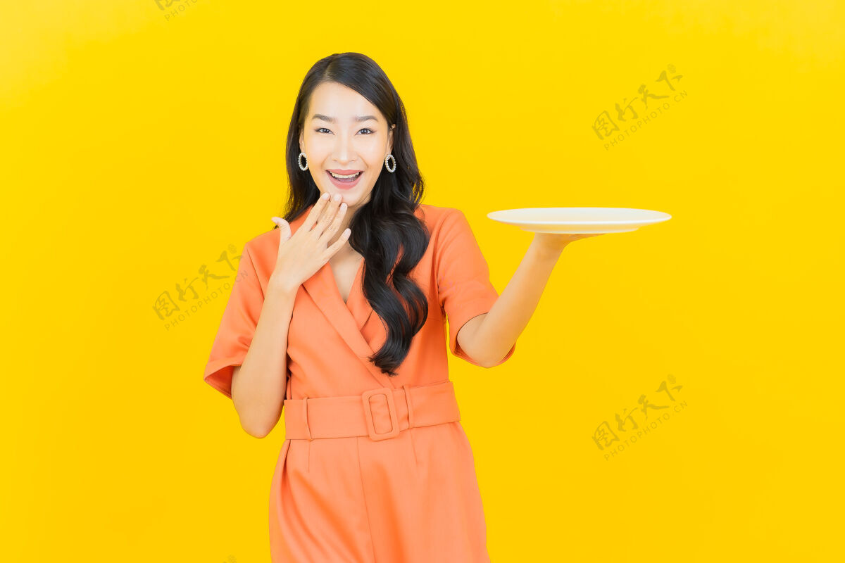 面包师肖像美丽的亚洲年轻女子微笑 黄色的空盘子碗食物喜悦