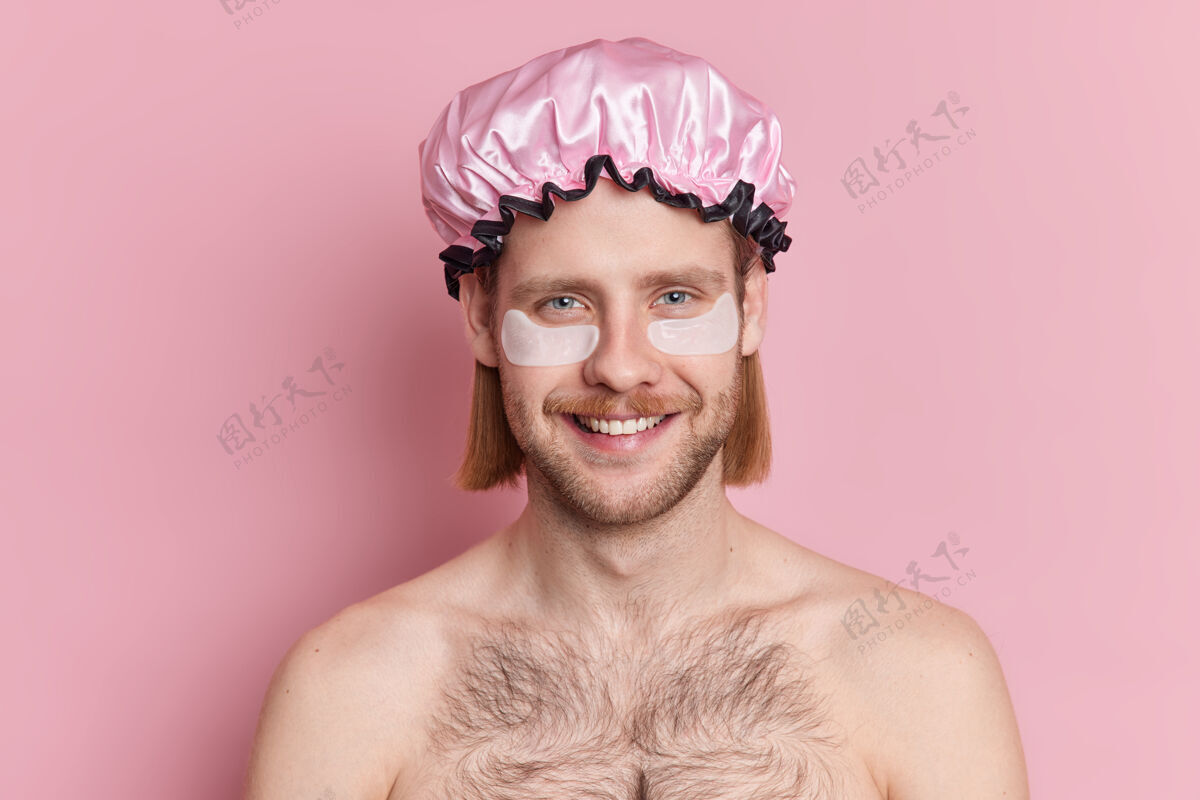 白种人开朗的欧洲男人笑容可掬地把胶原蛋白垫敷在眼睛下面接受美容治疗 然后赤膊上阵洗澡男人男人请