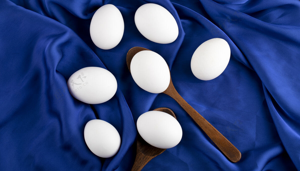 勺子一堆生鸡蛋 用木勺放在蓝色的棉布上木头烹饪天然