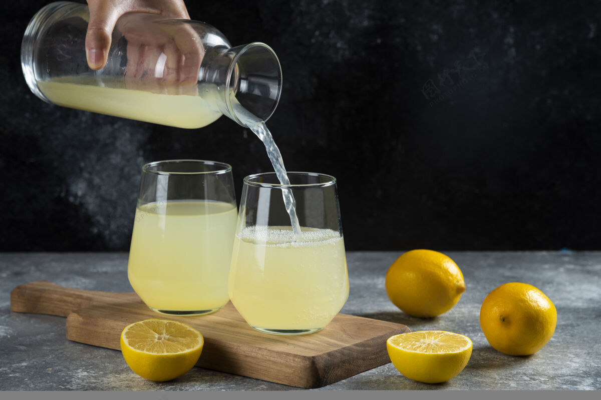 切片一只手把柠檬汁倒进杯子里冷刷新罐子