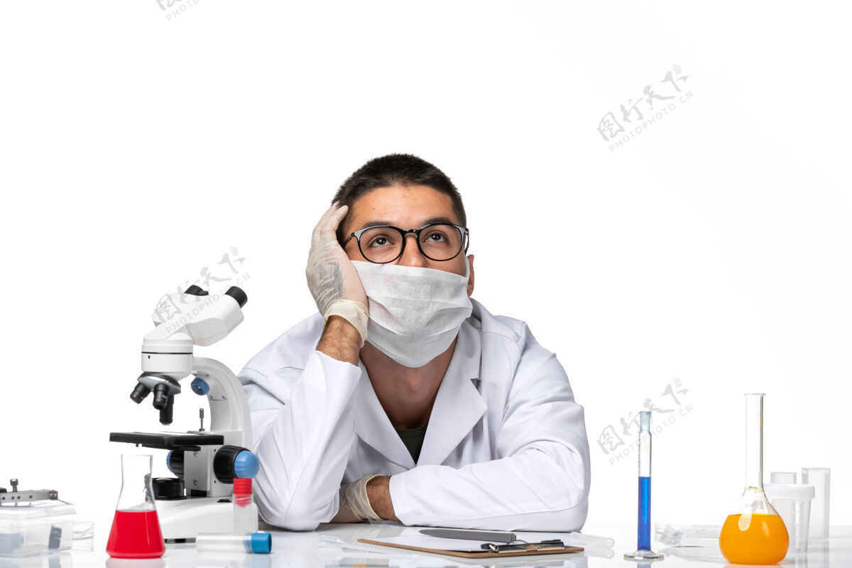 男医生正面图：男医生穿着白色医疗服 戴着面具 在白色空间紧张地摆姿势压力外套医生