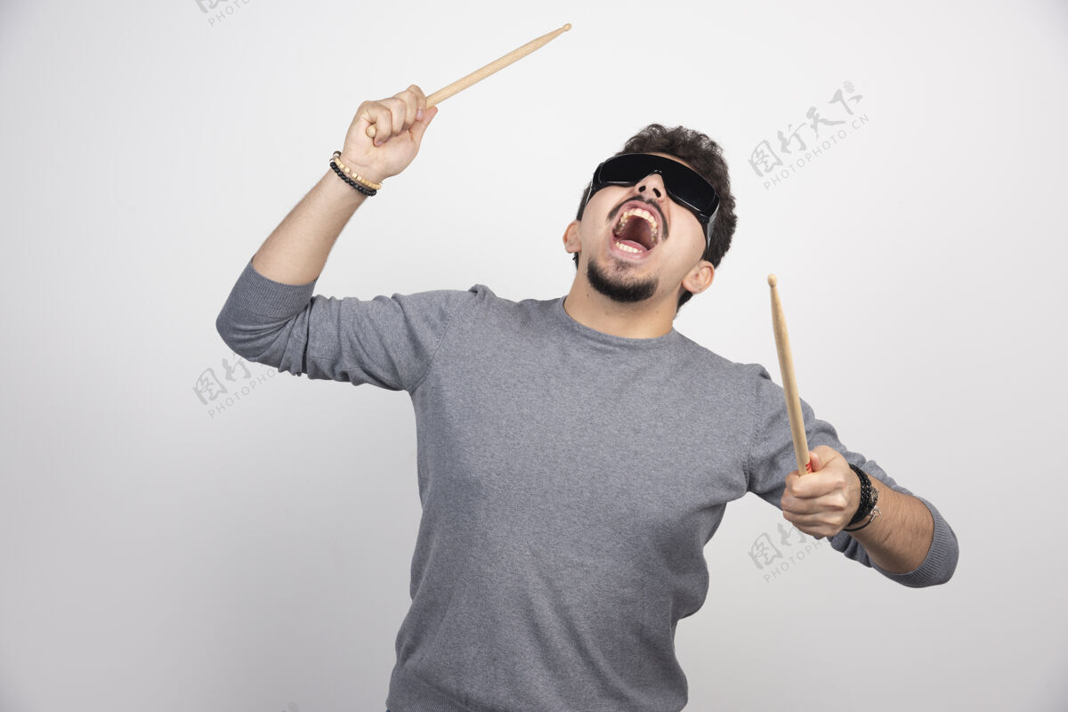 灵感一个戴着黑色太阳镜的鼓手拿着鼓棍 看上去很有活力热情音乐家音乐