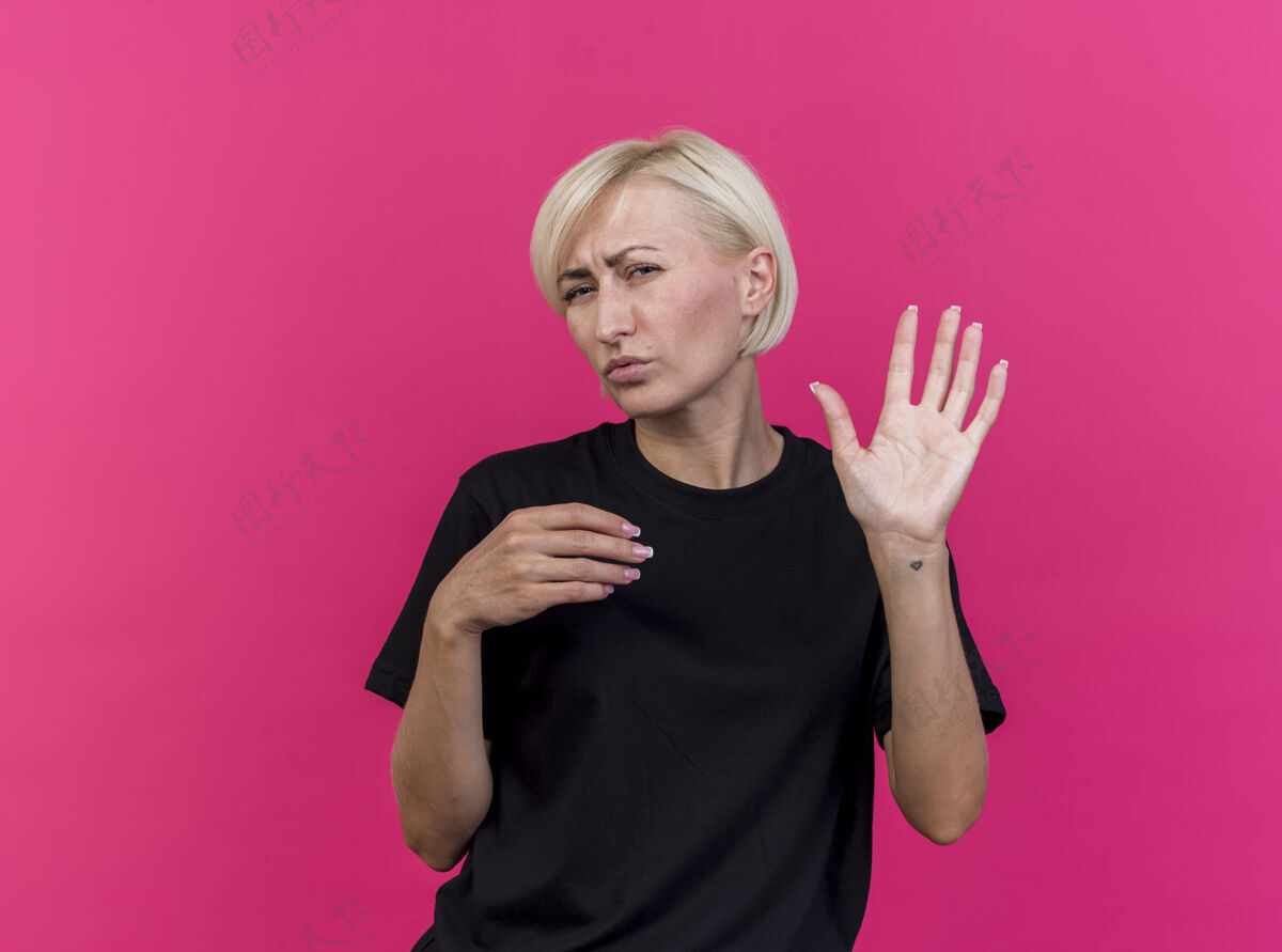 展示皱着眉头的中年金发斯拉夫女人看着前面的五只手 把另一只手放在空气中 隔离在粉红色的墙上 留着复印空间人金发斯拉夫