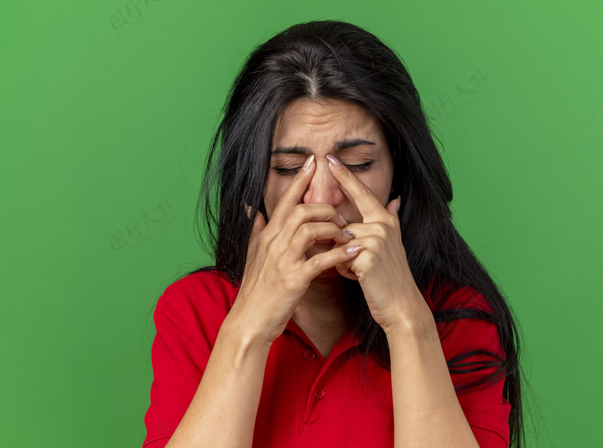 特写特写镜头：疼痛的年轻患病妇女把手指放在鼻子上 闭上眼睛 隔离在绿色墙壁上 留有复制空间闭着表情鼻子