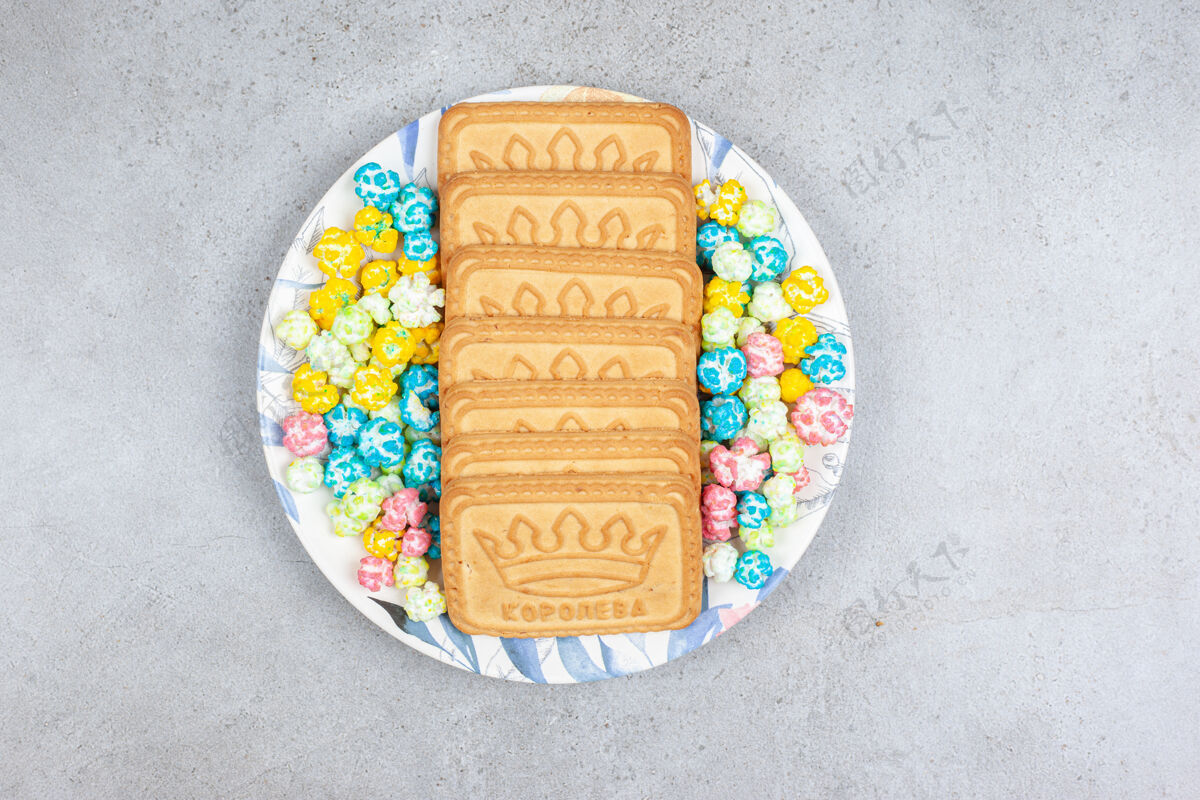 配料饼干和爆米花糖放在大理石背景的盘子上高质量的照片糖果膳食营养