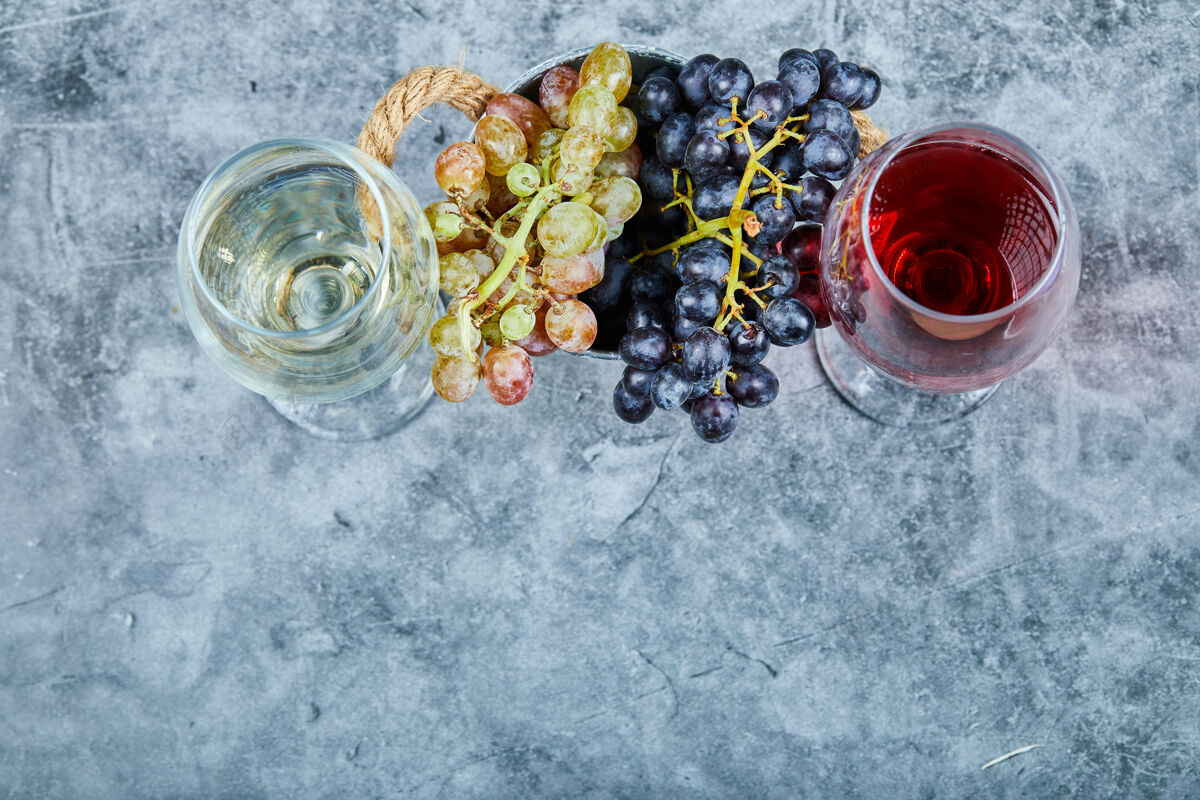 食物一束白葡萄和黑葡萄 两杯白葡萄酒和红葡萄酒 蓝色背景高品质照片葡萄新鲜葡萄酒