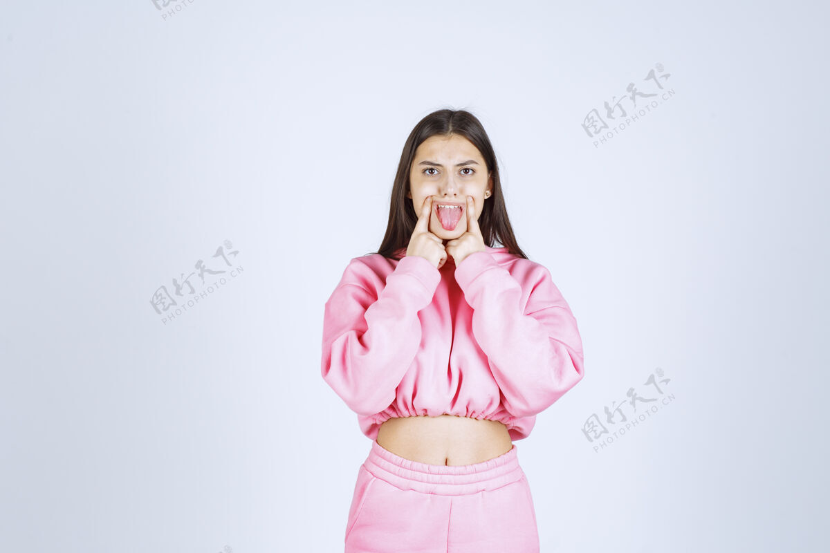 牙齿穿着粉色睡衣的女孩指着她的嘴装备口腔成人