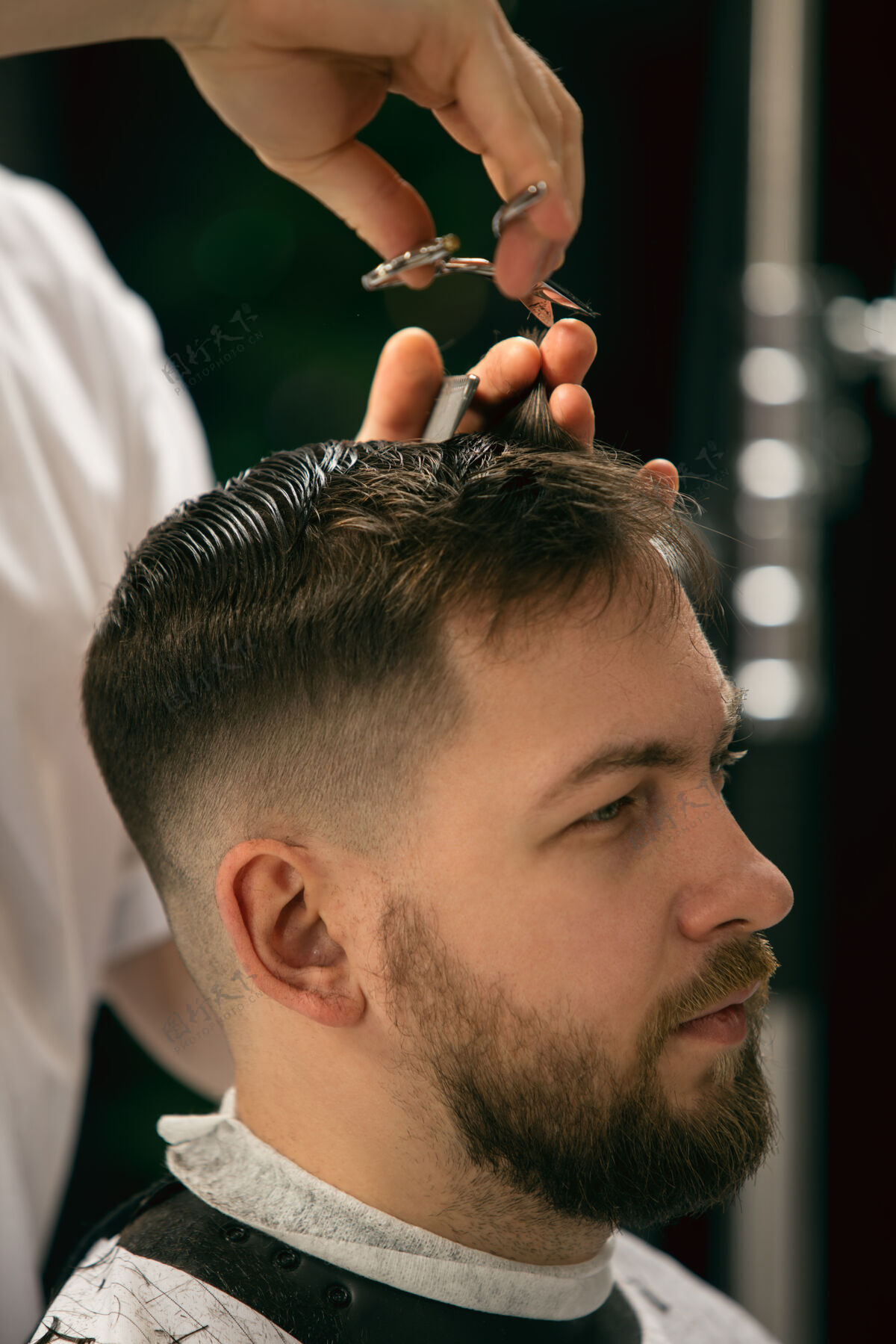 剃刀特写大师理发师 发型师给男生 年轻人做发型专业职业 男性美容理念客户的头发 胡子 胡须的护理柔和的颜色和焦点 复古毛巾剪理发师