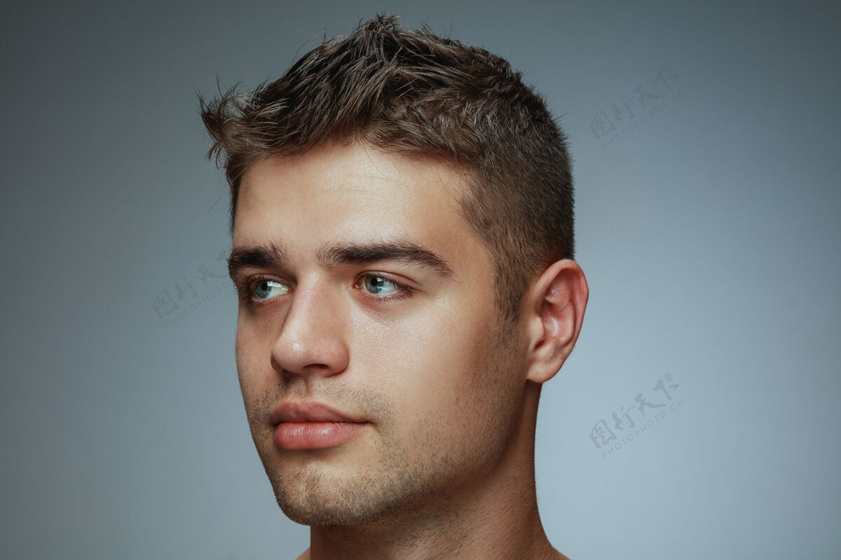 脸隔离在灰色工作室背景上的赤膊青年的肖像白种人健康的男模看侧面和摆姿势男人的健康和美丽 自我护理 身体和皮肤护理的概念皮肤姿势干净