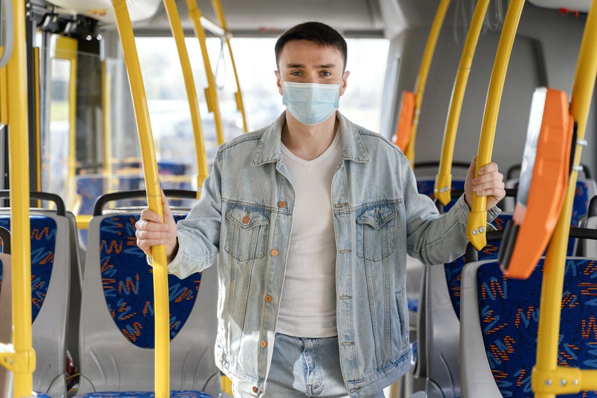 感染预防年轻人戴着口罩坐公交车汽车乘客城市公共汽车