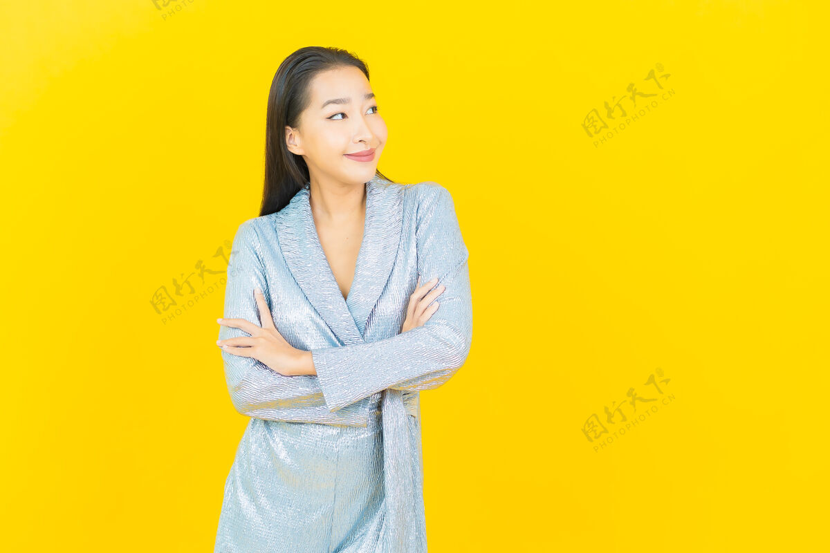 女孩在黄色的墙上描绘美丽的亚洲年轻女子微笑着行动成人女人欢呼