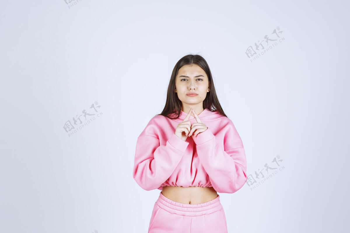 没有经验穿粉红色睡衣的女孩看起来既困惑又怀疑人女性女人
