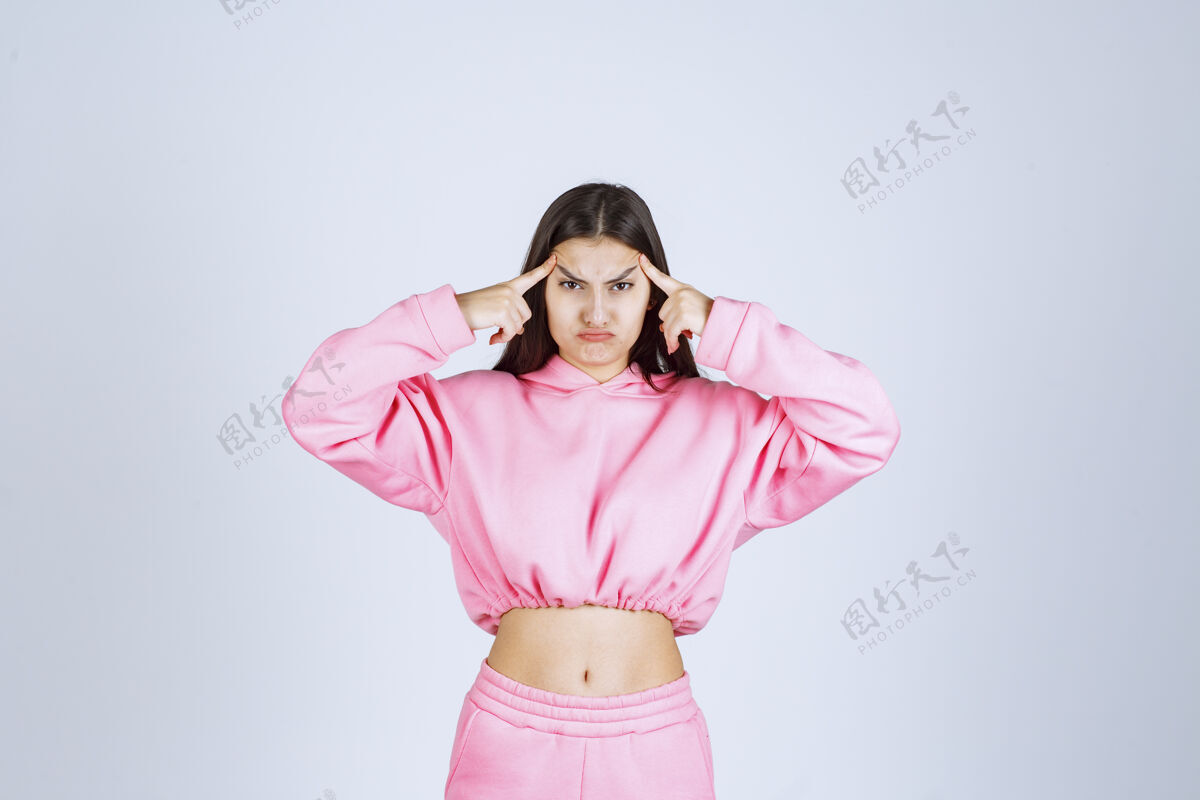 休闲穿粉红色睡衣的女孩看起来既困惑又怀疑女性姿势女人