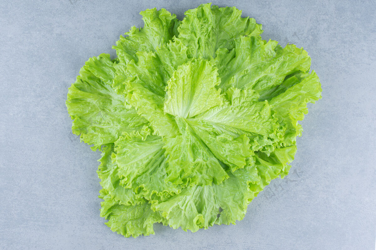 视图在灰色背景上特写莴苣叶子的照片顶部新鲜饮食