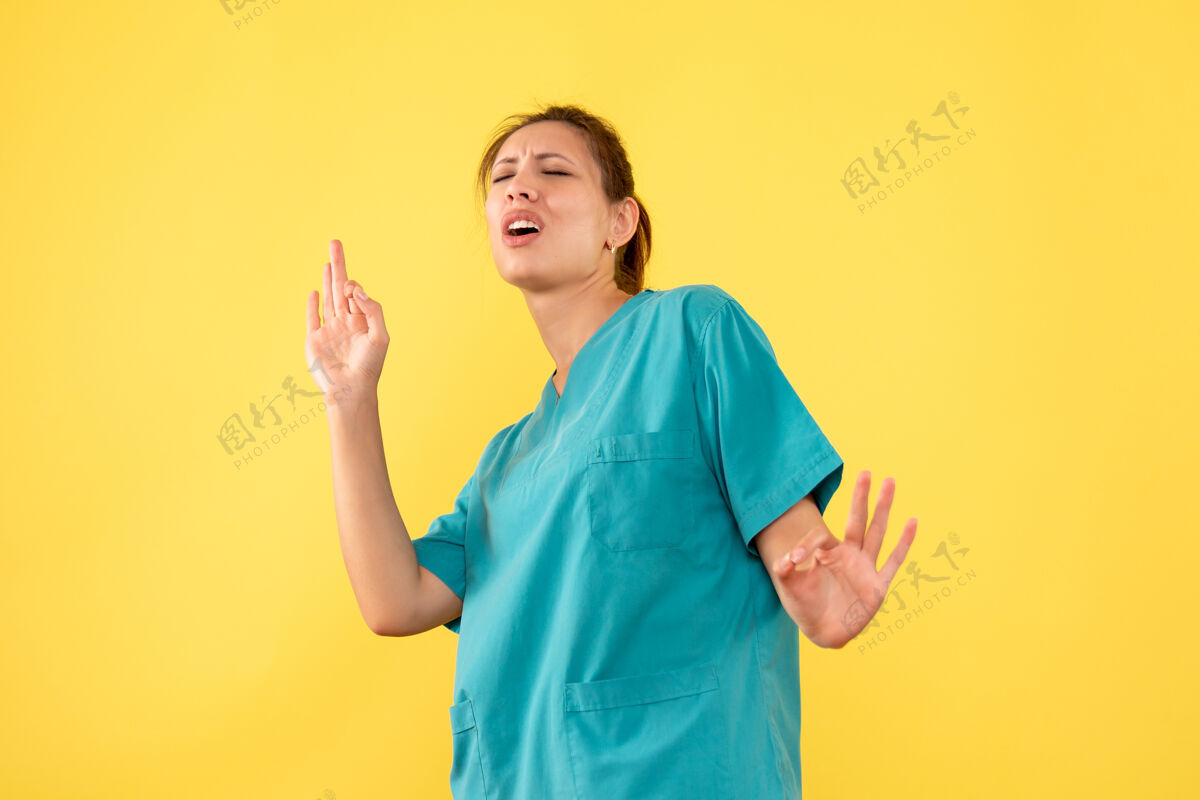 肖像前视图黄色背景上穿着医用衬衫的女医生黄色人衬衫
