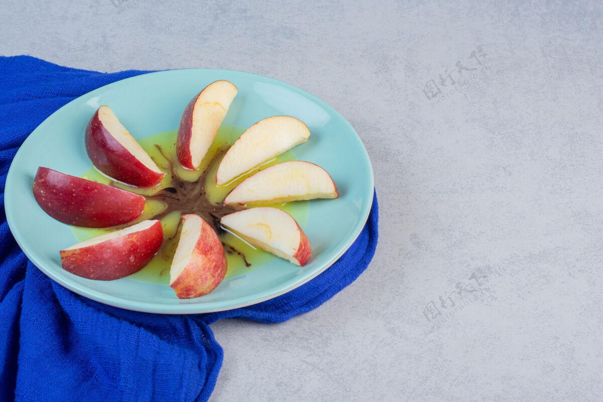甜点新鲜的红苹果蓝色盘子上的切片自然水果新鲜