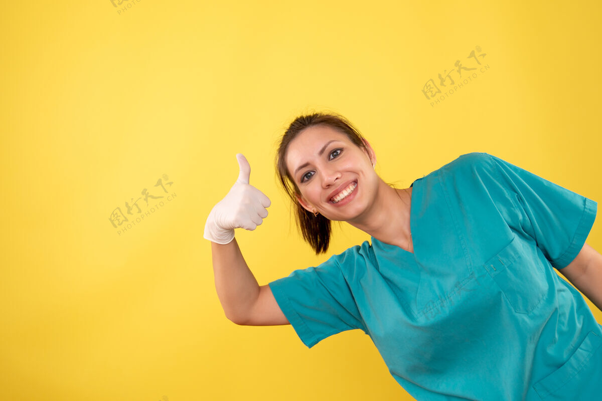 人前视图黄色背景上戴着医用手套的女医生视图女医生手套
