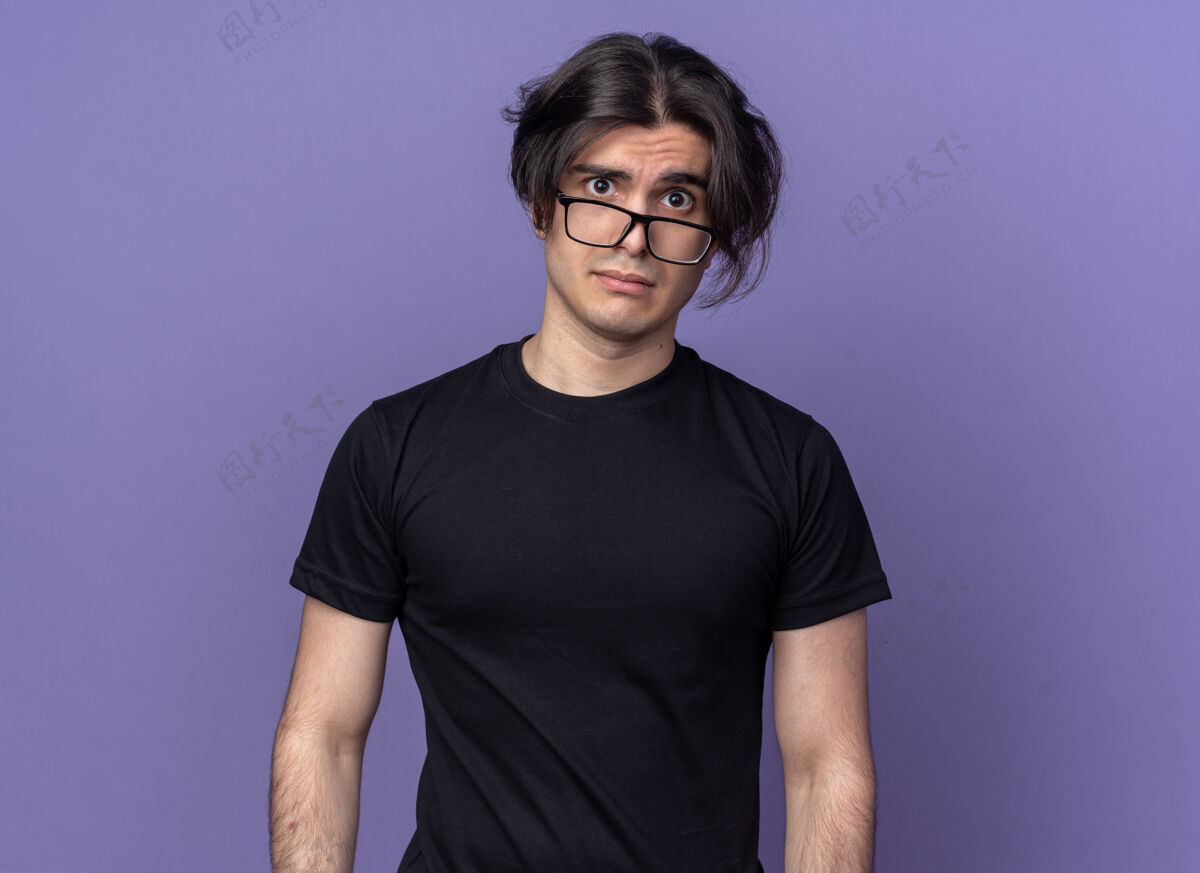 T恤一个穿着黑色t恤 戴着眼镜的年轻帅哥被隔离在紫色的墙上小伙子年轻讨厌