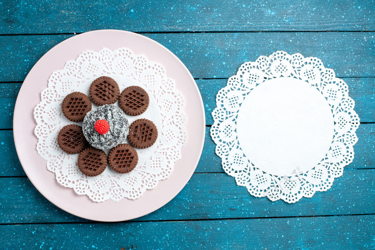 陶瓷器皿俯瞰美味的巧克力饼干与巧克力蛋糕上的蓝色乡村办公桌饼干茶饼干甜蛋糕糖容器瓷器顶部