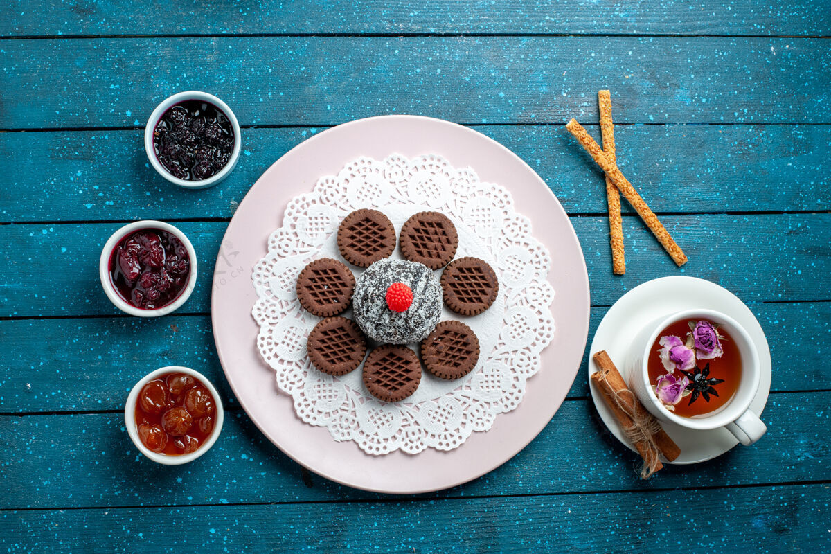 视图俯瞰美味的巧克力饼干 配果酱和一杯茶 放在蓝色的乡村办公桌上饼干茶饼干甜甜的蛋糕糖容器饼干瓷器