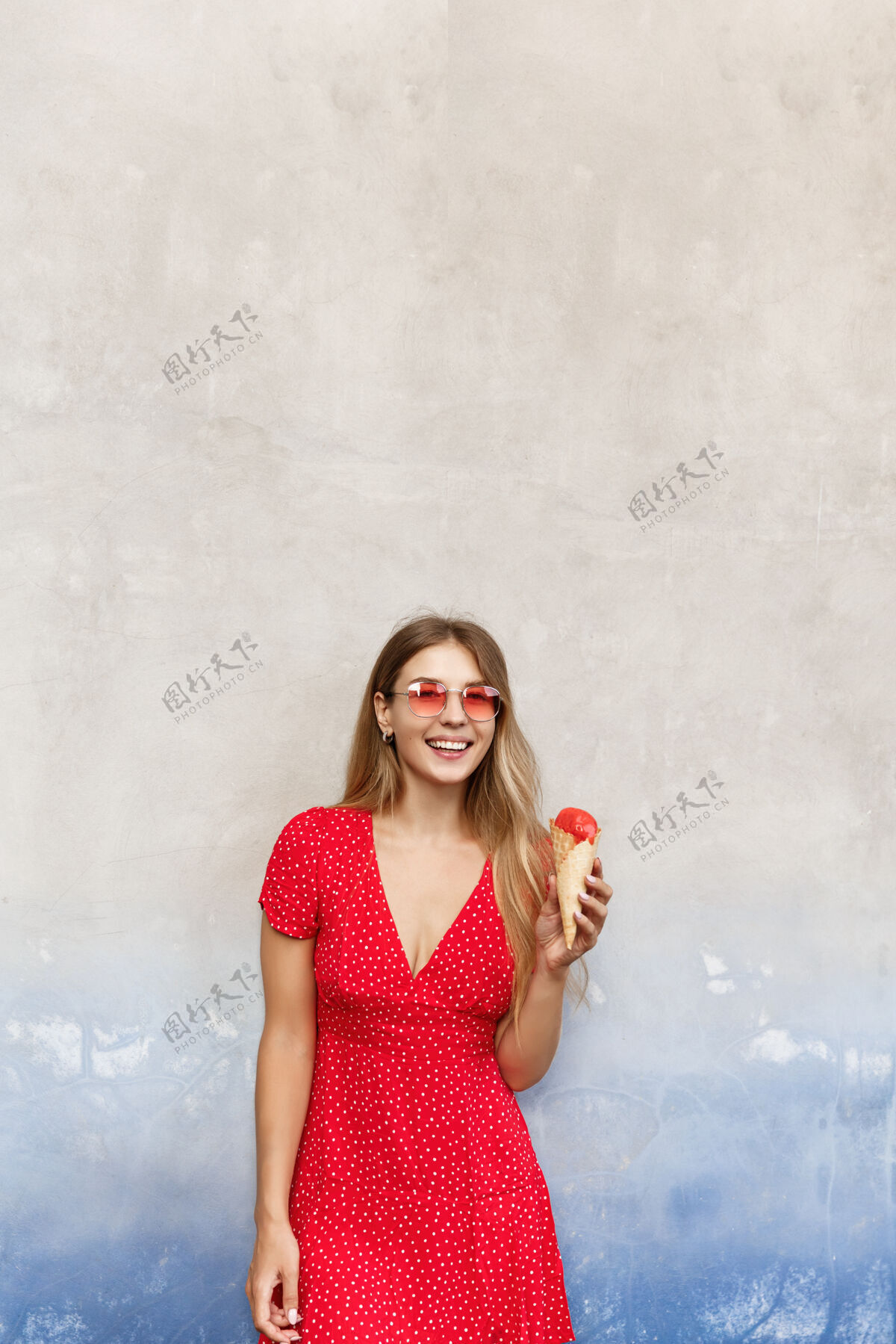 都市夏日女孩在街上吃冰淇淋 对着镜头微笑的垂直镜头梦幻女孩街头