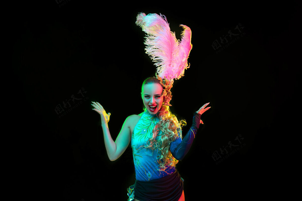 意大利美丽的年轻女子在狂欢节和化装舞会服装在五颜六色的霓虹灯黑色华丽魅力里约热内卢