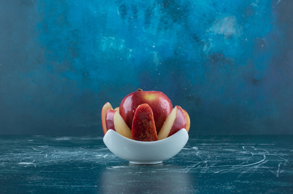 口味把整个红苹果切成片放在白碗里水果新鲜有机