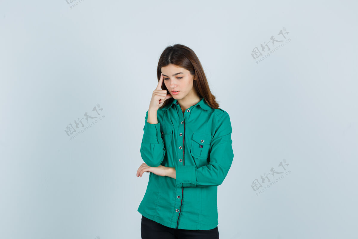 坐着穿着绿衬衫的年轻女士站在思考的姿势里 看起来很不安前视图女士担心女性