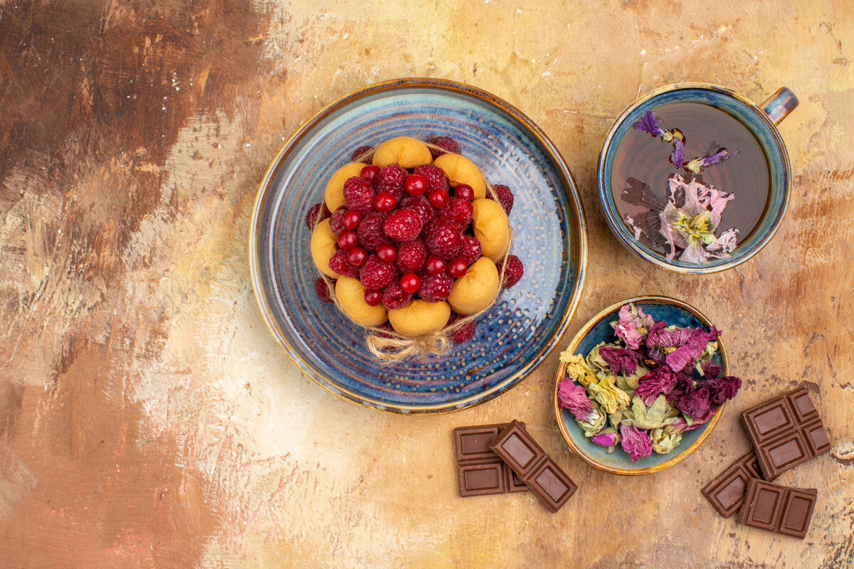 软蛋糕一杯热花草茶的水平视图软蛋糕与水果和鲜花巧克力条浆果可食用水果新鲜