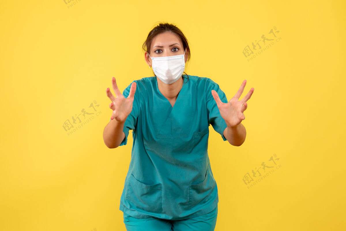 人前视图黄色背景上穿着医用衬衫和面罩的女医生女医生手肖像