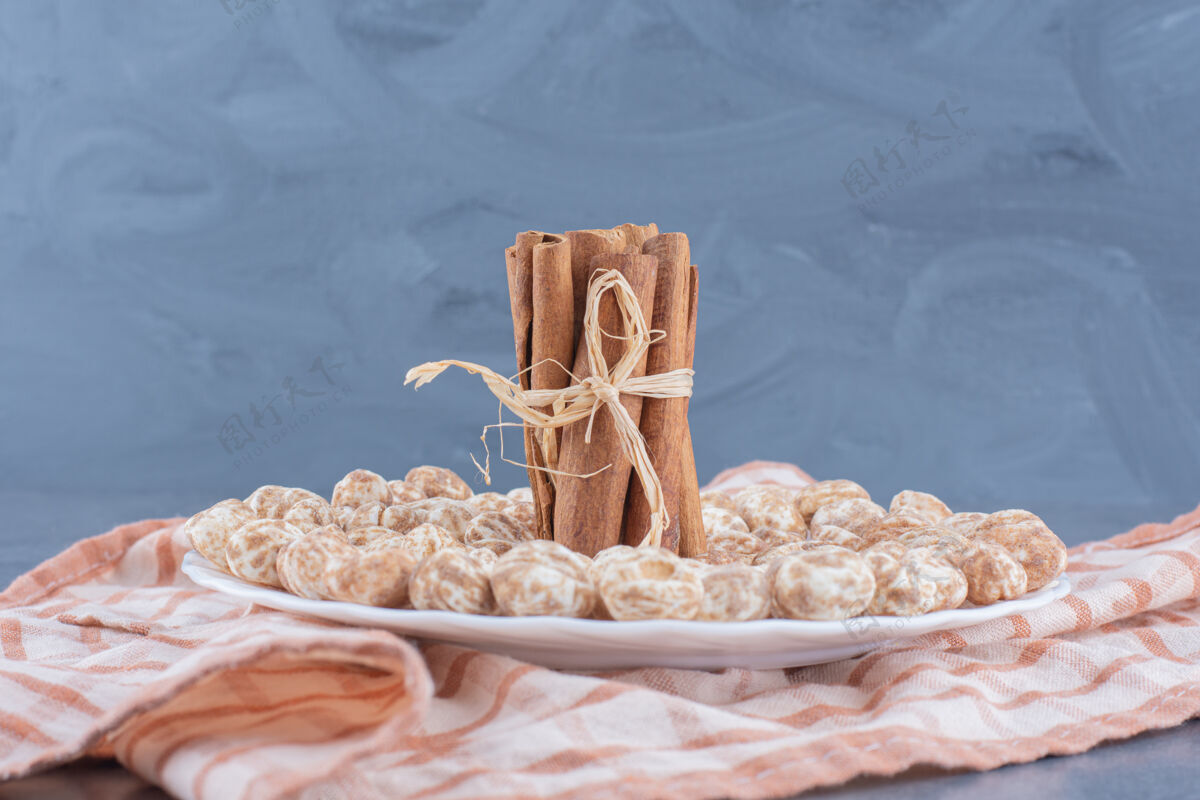 甜点肉桂棒和饼干放在毛巾上 大理石背景上美味毛巾垃圾食品